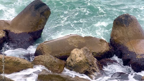 Stormy ocean waves crashing against breakwater rocks