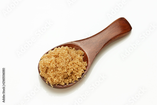 Foto Loose Brown Sugar on spoon close up on white background
