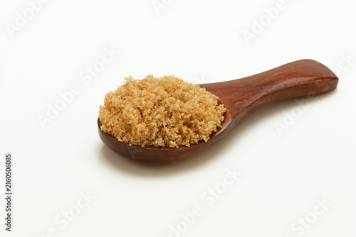 Foto Loose Brown Sugar on spoon close up on white background