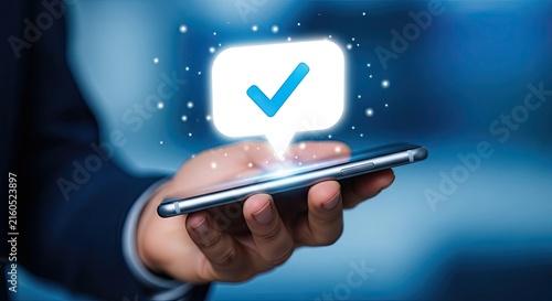 Businessman holding a smartphone with a glowing digital checkmark icon representing success and task completion concept