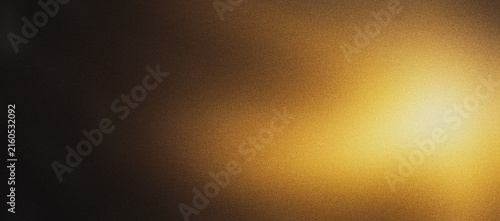 Cinematic lens flare with warm golden light on dark background. Vintage film grain texture with soft amber glow. Retro light leak effect for overlays. Moody sun flare for creative photography.