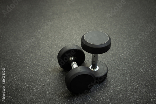 фотографія This monochrome photo shows two dumbbells lying on the gym floor, emphasizing the simplicity and purposefulness of training and strength exercises