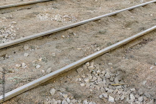 Tram rails run through loose gravel and stones at a repair site