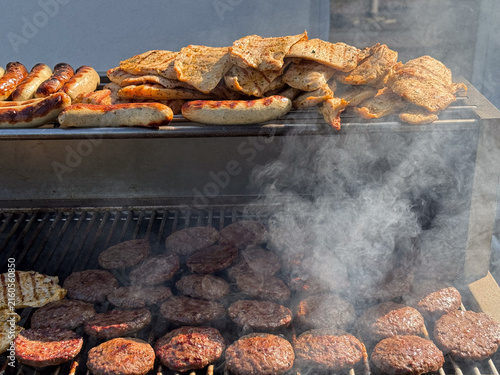 Grilled sausages steaks and burger patties on barbecue grill