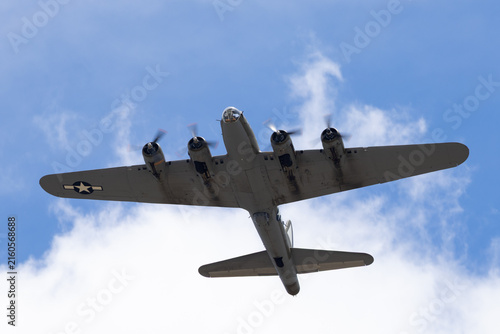 Close bottom view of a WWII bomber (B-17 Flying Fortress) against clouds