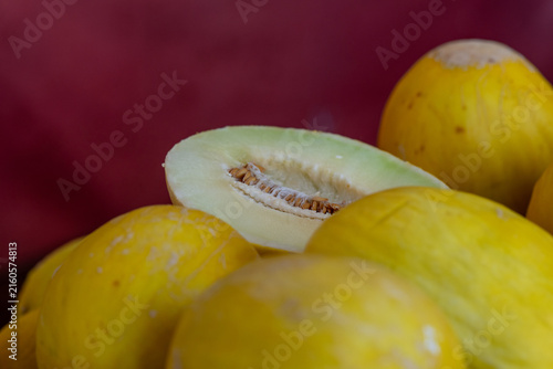 Fotografie Honeydew melons are stacked in a bin for sale at a supermarket