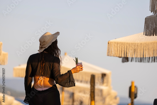 Woman enjoying sunset view with refreshing cocktail