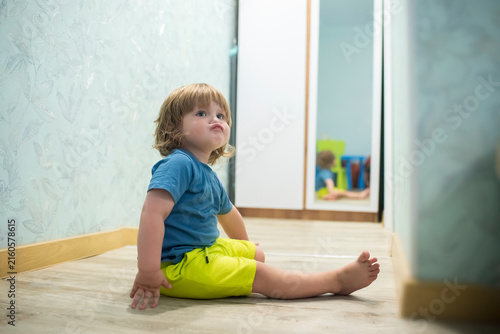 Quadro su tela Stubborn toddler boy pouting and sitting on floor at home