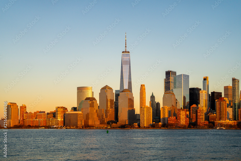Fototapeta premium NYC Manhattan panorama city skyline. NYC Manhattan skyline glowing at dusk. NYC Manhattan skyline with downtown towers. NYC Manhattan skyline travel destination.