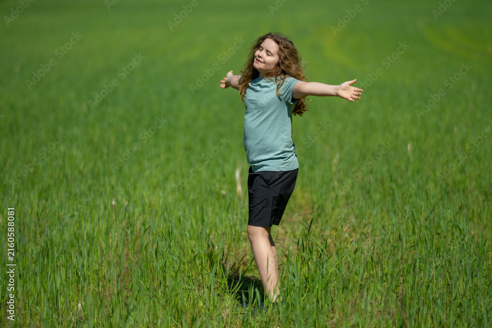Fototapeta premium Kid enjoys mindful outdoor freedom. Kid breathes fresh summer air. Happy kid feels calm meditation. Playful kid shows carefree joy.