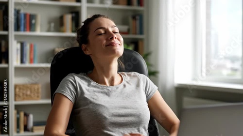 Woman sitting at home smiling in soft daylight with relaxed posture