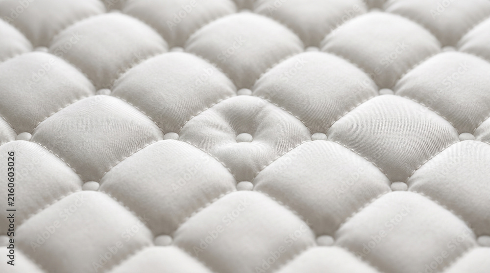 Naklejka premium Closeup of a soft white quilted mattress fabric texture with tufted buttons