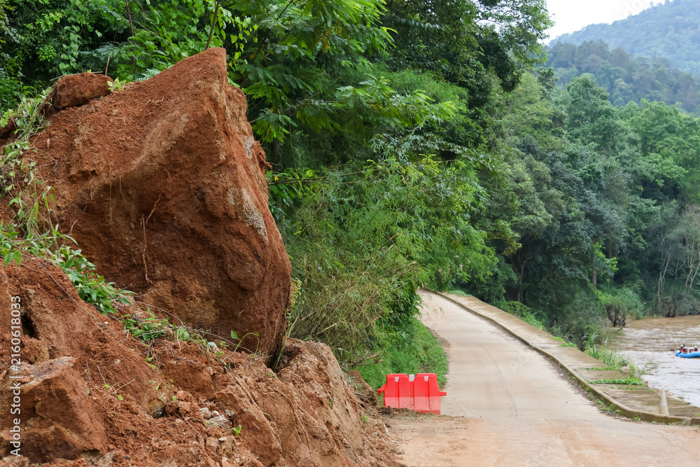 Fototapeta premium Tropical forest red soil landslide mountain road green vegetation rural landscape