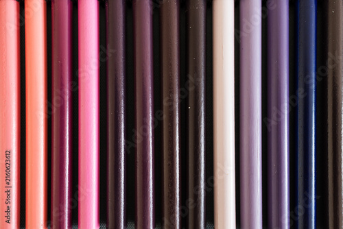 close-up of pink purple and violet colored pencils neatly lined up in pencil case, concept of creativity, drawing, education and art supplies
