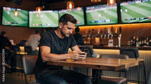 Man using smartphone in a lively sports bar with energetic crowd and vibrant atmosphere