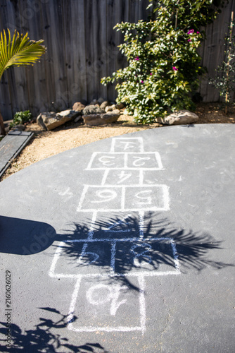 chalk hopscotch game drawn on concrete patio in australian backyard