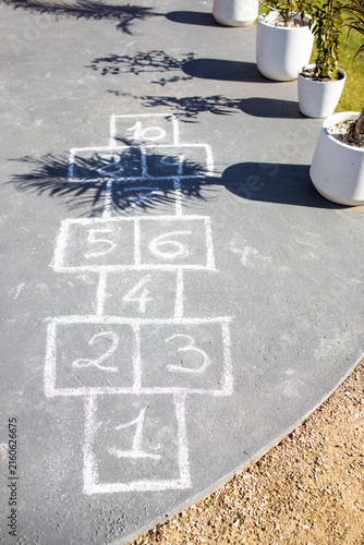chalk hopscotch game drawn on concrete patio in australian backyard