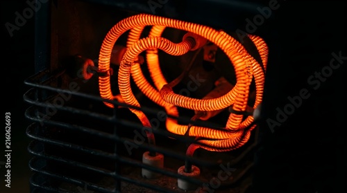 Glowing red electric heater coils warming in a cold dark room interior