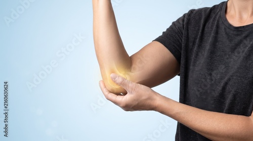 Man holding painful elbow joint with glowing effect, concept of arthritis or injury pain relief treatment, medical healthcare background for therapy and rehabilitation services.