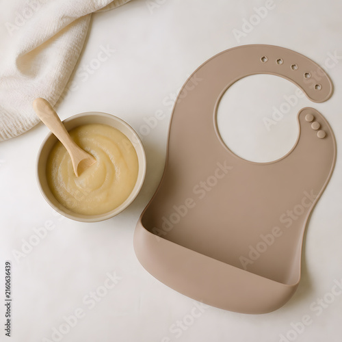 Baby food porridge with spoon and bib