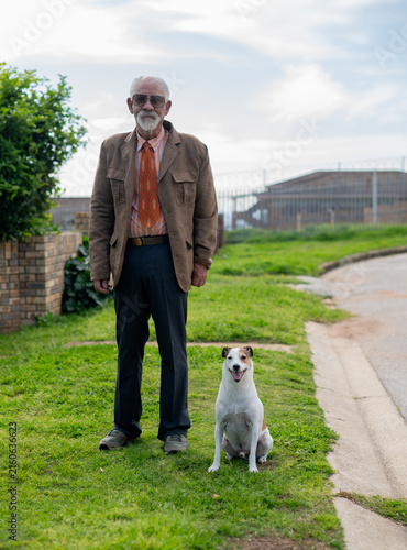 Senior man and his dog seen standing outdoors