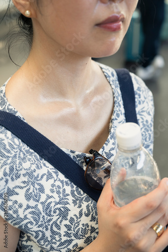 Sweaty Woman Holding Water in Tokyo Heat