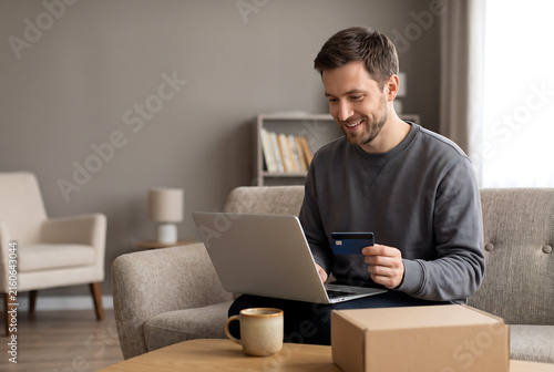 Man shopping online with credit card and laptop at home