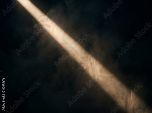 Dramatic golden light beam piercing through dark haze for atmospheric effect