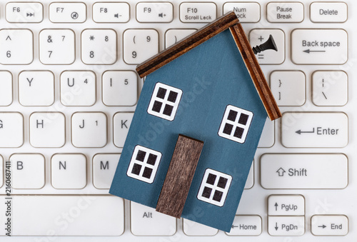 A symbolic wooden house and a white computer keyboard.
