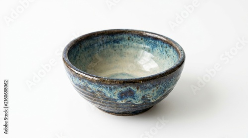 Handmade blue ceramic bowl with mottled glaze on white background