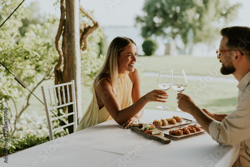 Quadro su tela Enjoying a delightful meal together by the peaceful lakeside at golden hour