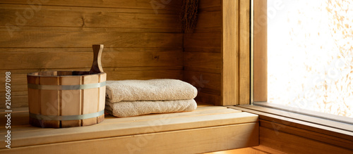 Foto Wooden sauna interior features neatly folded towels and a wooden bucket