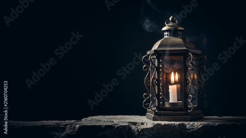 Vintage lantern glowing on dark stone surface with mysterious halloween atmosphere