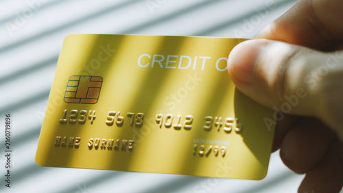 Smart shopping choice, hand pick up golden credit card for purchase online shopping. business debt concept.