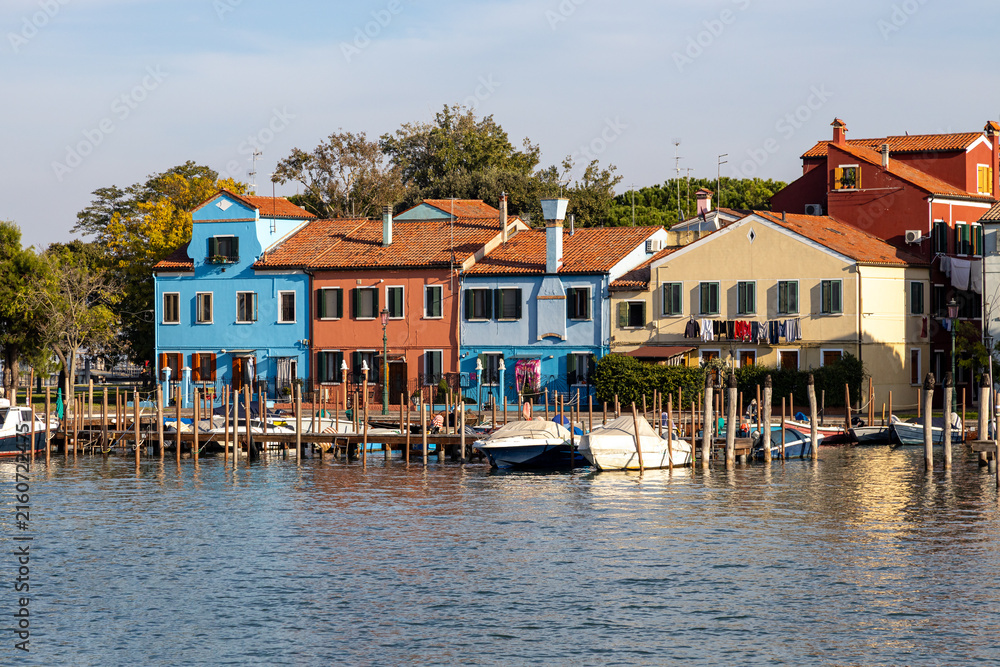 Obraz premium Colorful houses and boats along the Venetian Lagoon on the picturesque island of Burano, Venice, Italy