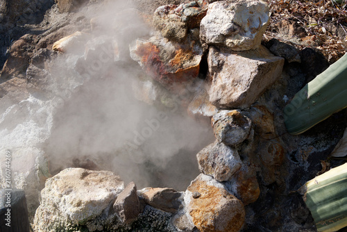 Canvastavla Hot geothermal steam rising from a natural stone thermal vent with sulfur mineral deposits under bright sunlight