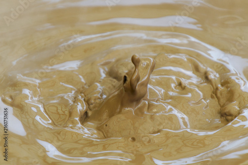 High-speed macro shot of boiling thermal mud splash creating a column and ripples in a geothermal hot spring.