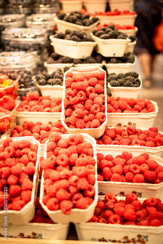 Vertical photo shows raspberries in a display of a local market.