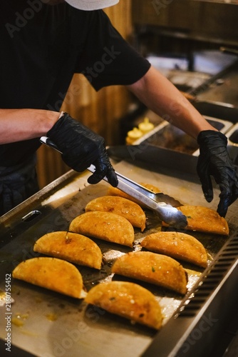 Fotografie Authentic Mexican food preparation, chef grilling greasy, savory beef tacos with