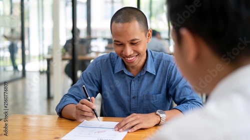 Happy Indonesian professional business man executive hr or bank manager, lawyer or financial advisor having job interview or business conversation consulting client at corporate office meeting.