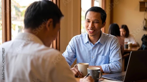 Happy Indonesian professional business man executive hr or bank manager, lawyer or financial advisor having job interview or business conversation consulting client at corporate office meeting.