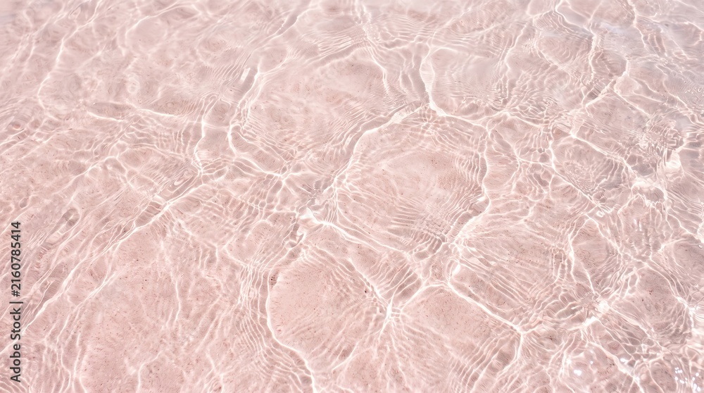 Fototapeta premium Pink water surface texture with caustic light reflections and gentle ripples background