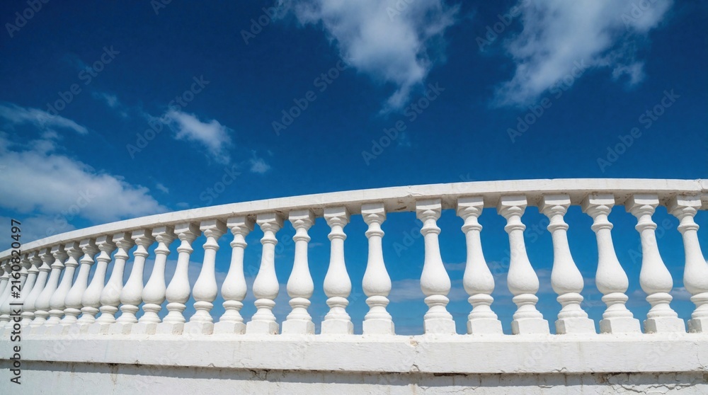Fototapeta premium White stone balustrade stands against bright blue sky with fluffy clouds. Classic architecture railing on terrace bridge overlooking summer landscape. Minimalist background for travel, holiday