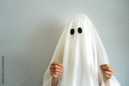 Bild auf Leinwand Funny Halloween ghost shrugging with open hands, representing confusion, doubt,