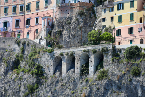 Colorful Clifftop Houses and Historic stone arches (known as Le Arcate) supporting the coastal roadway in the cliffside village of Atrani on the Amalfi Coast, Italy.