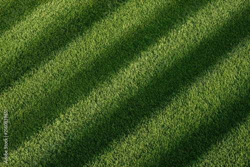 Close-up of neatly mowed grass with diagonal stripes of light and shadow