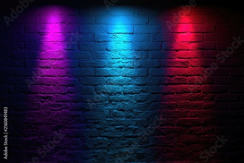 Textured brick wall illuminated by vibrant magenta, cyan, and crimson spotlights