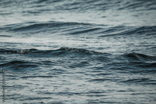 Картината върху платно Close-up photograph of dark blue sea with rippling waves and textured water surf