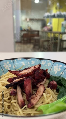 Close up view of noodle on the bowl. chicken charsiu and mustard greens leaves. side, front. mie, bakmi. copy space, empty, free, negative, text, design. vertical, potrait. lights, bright