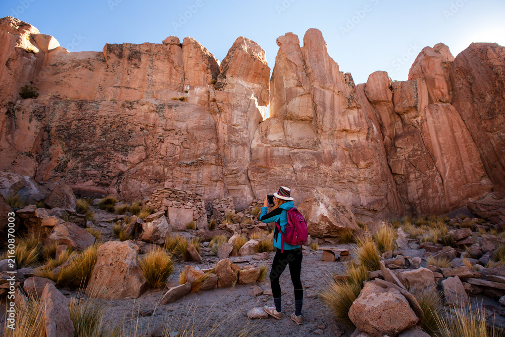Fototapeta premium Woman taking pictures in Rocky Canyon. Bolivia